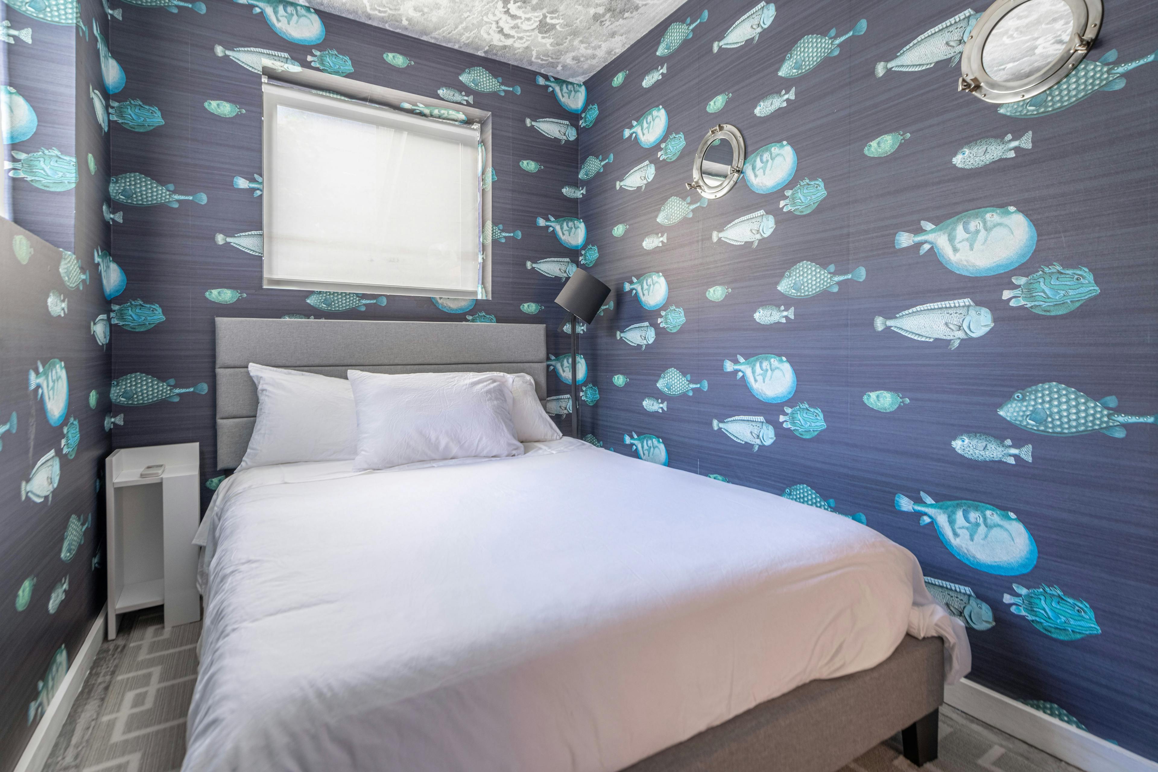 A luxury bedroom in New York or Brooklyn furnished with a fish-themed wallpaper.