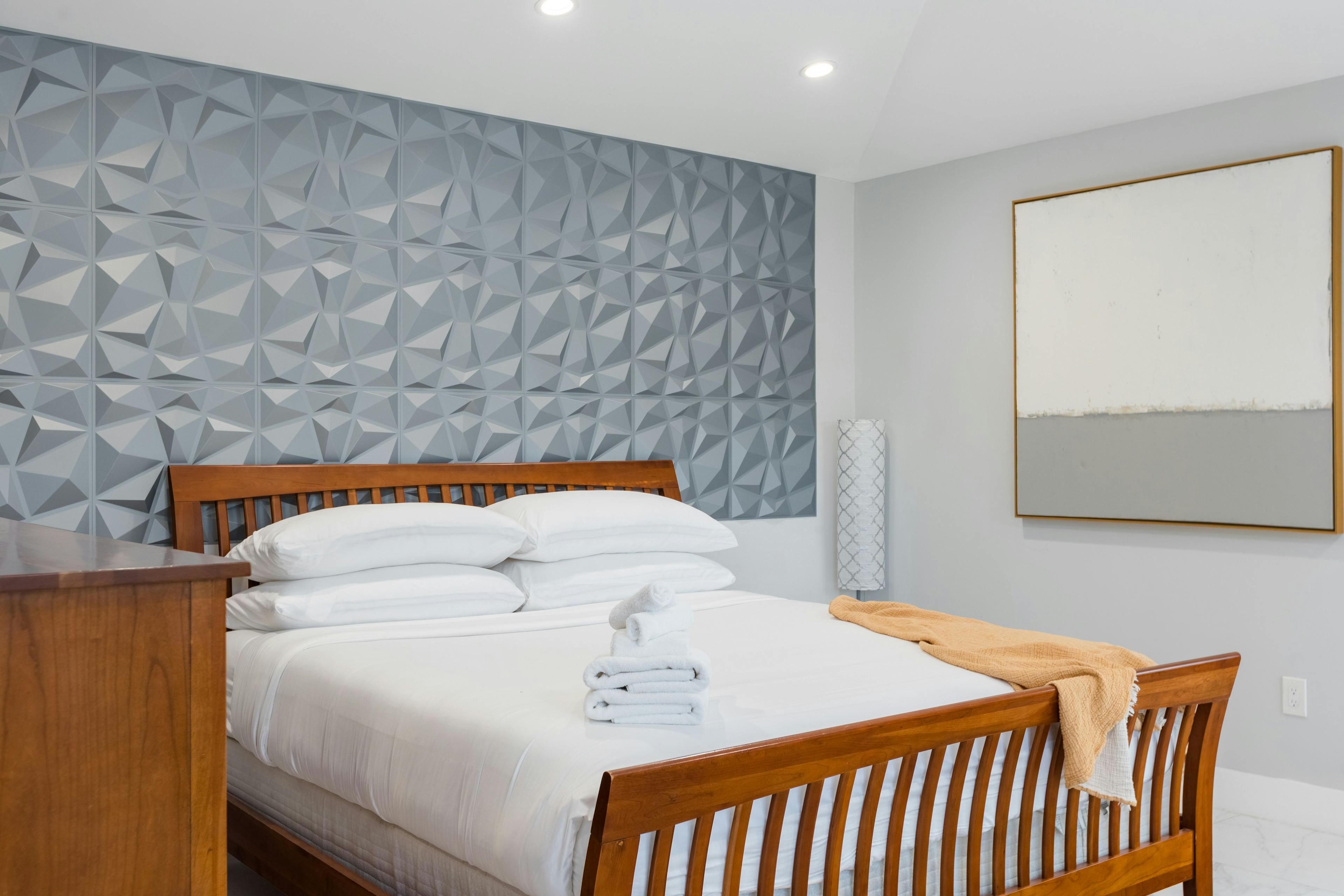 Bedroom with wooden bedframe and gray textured 3D wallpaper 