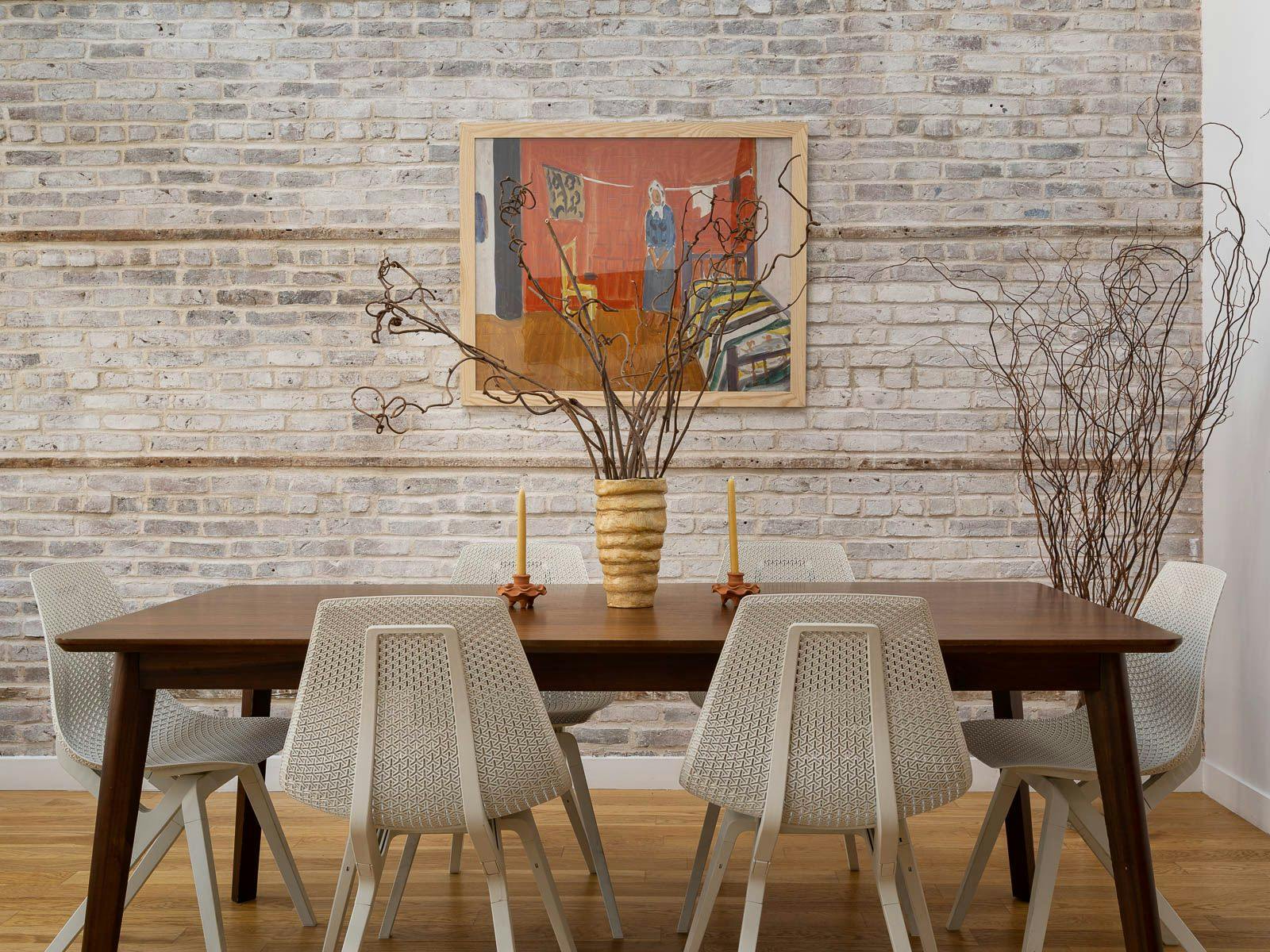 Modern Dining Room with Brick Wall, white chairs, wooden mid-century modern table with decor