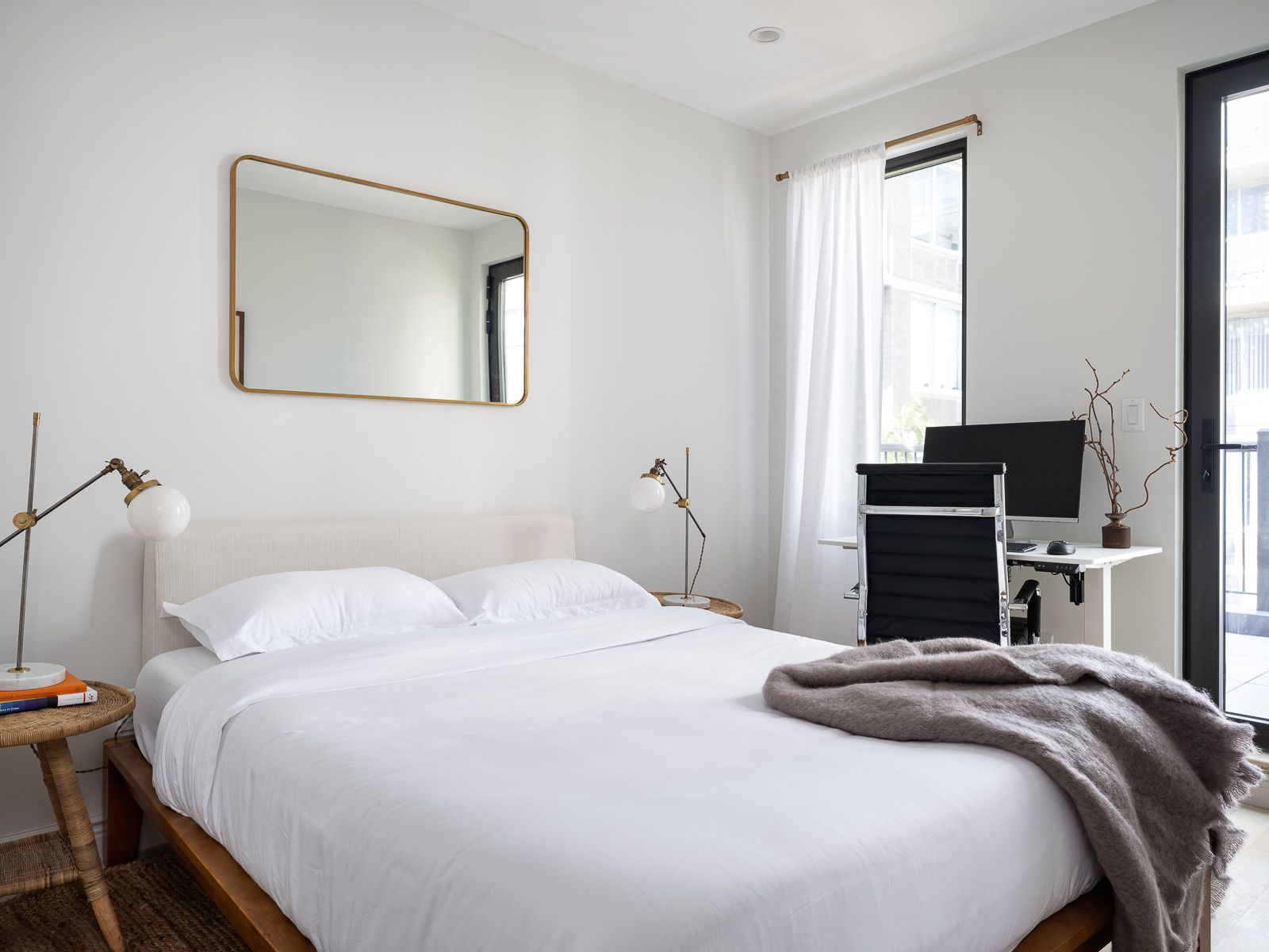 Beautifully designed and styled bedroom with a workstation comprised of a monitor and ergonomic chair