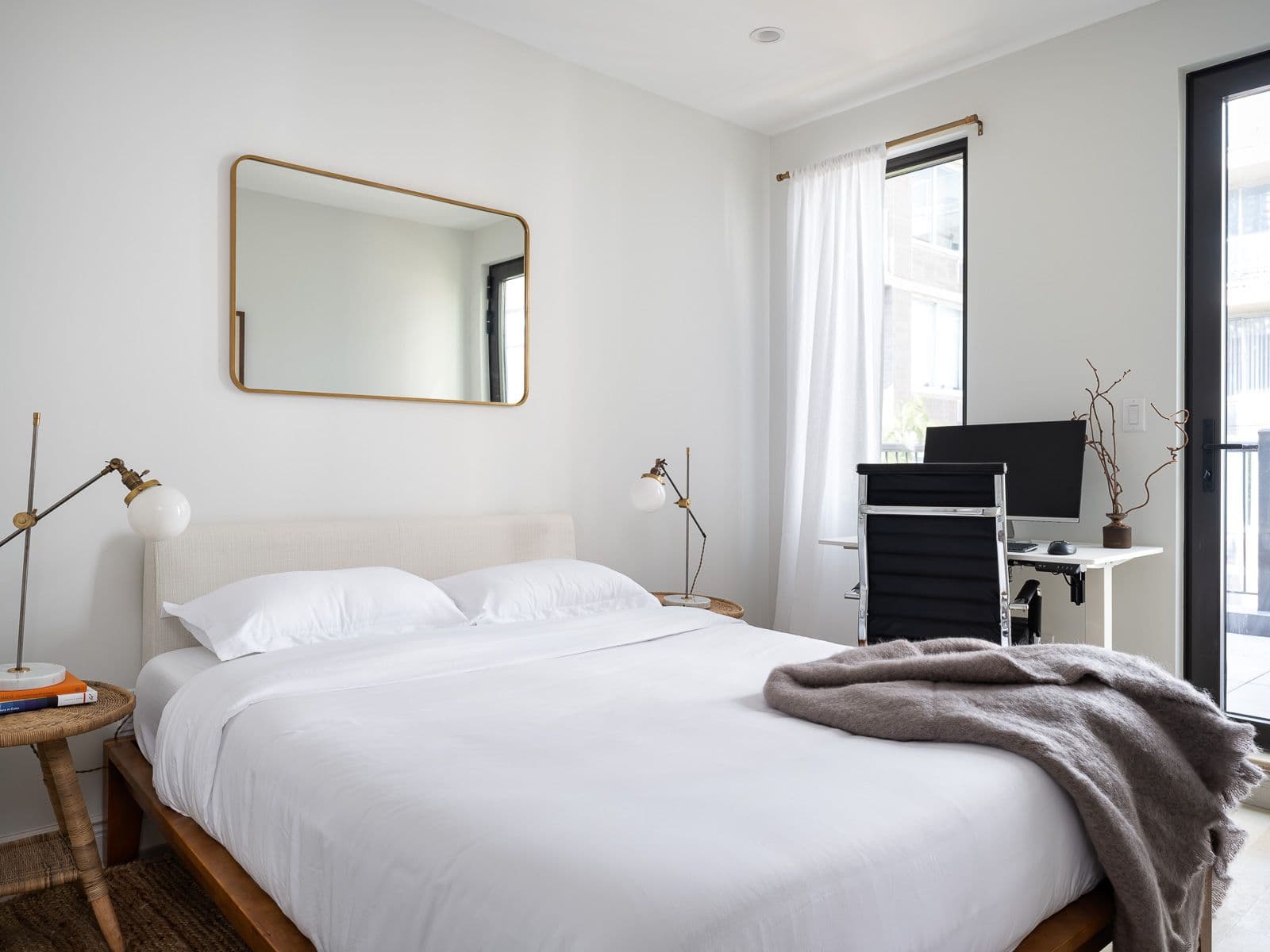 Beautifully designed and styled bedroom with a workstation comprised of a monitor and ergonomic chair