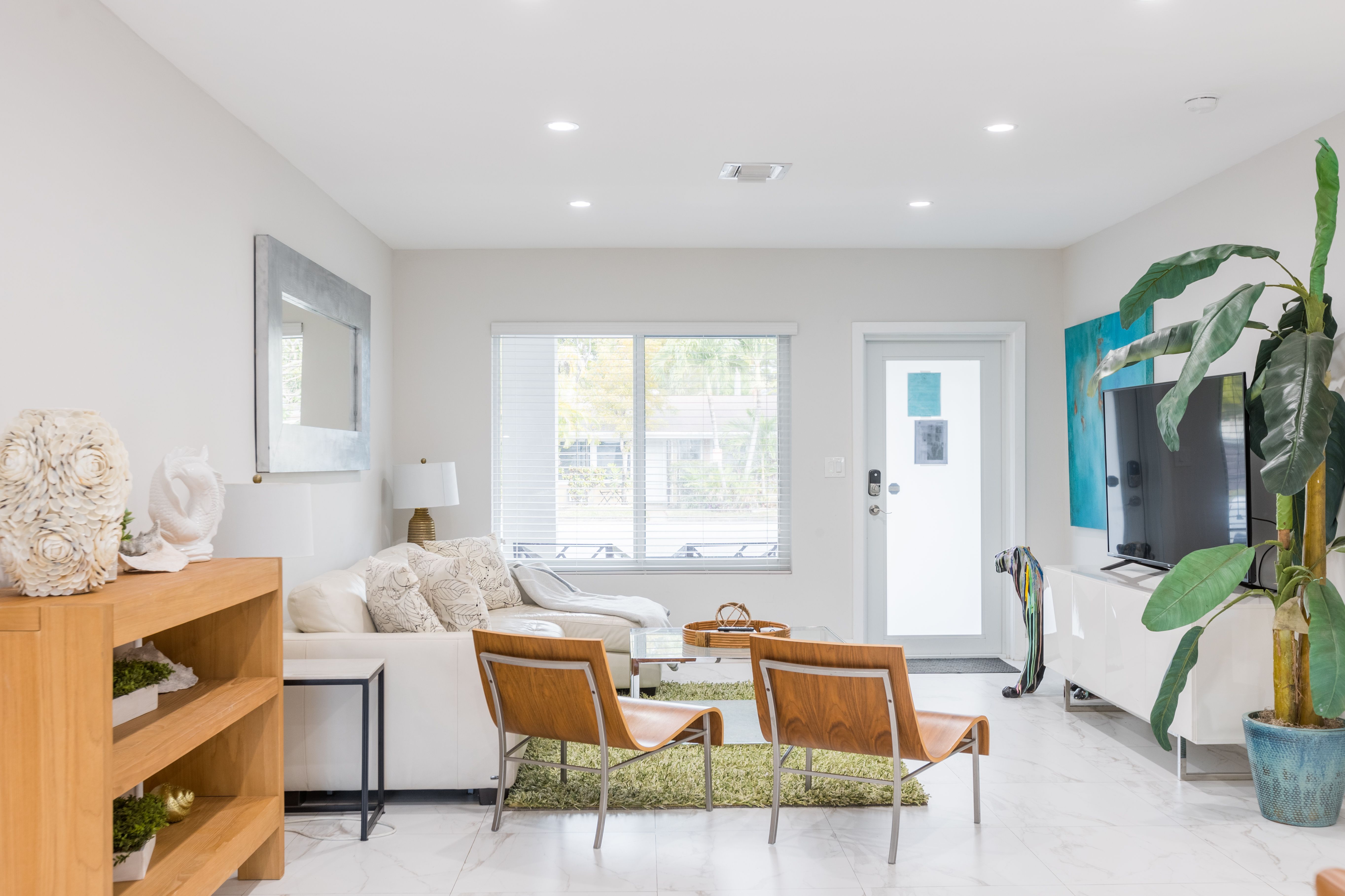 Spacious Living Room in Vacation Rental with two leather chairs and white sofa facing TV