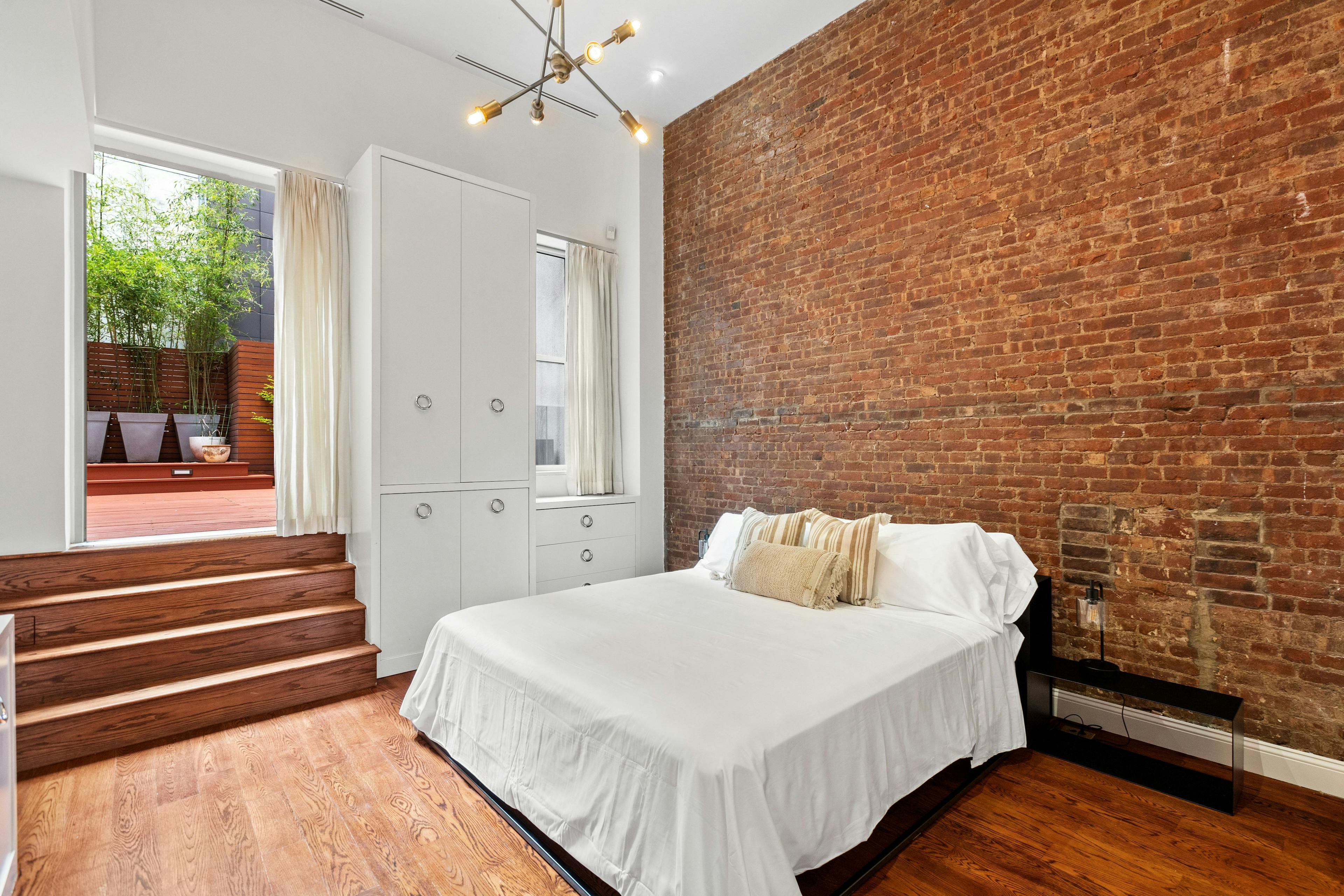 Large bedroom with patio access , Queen Bed, Accent brick wall,
