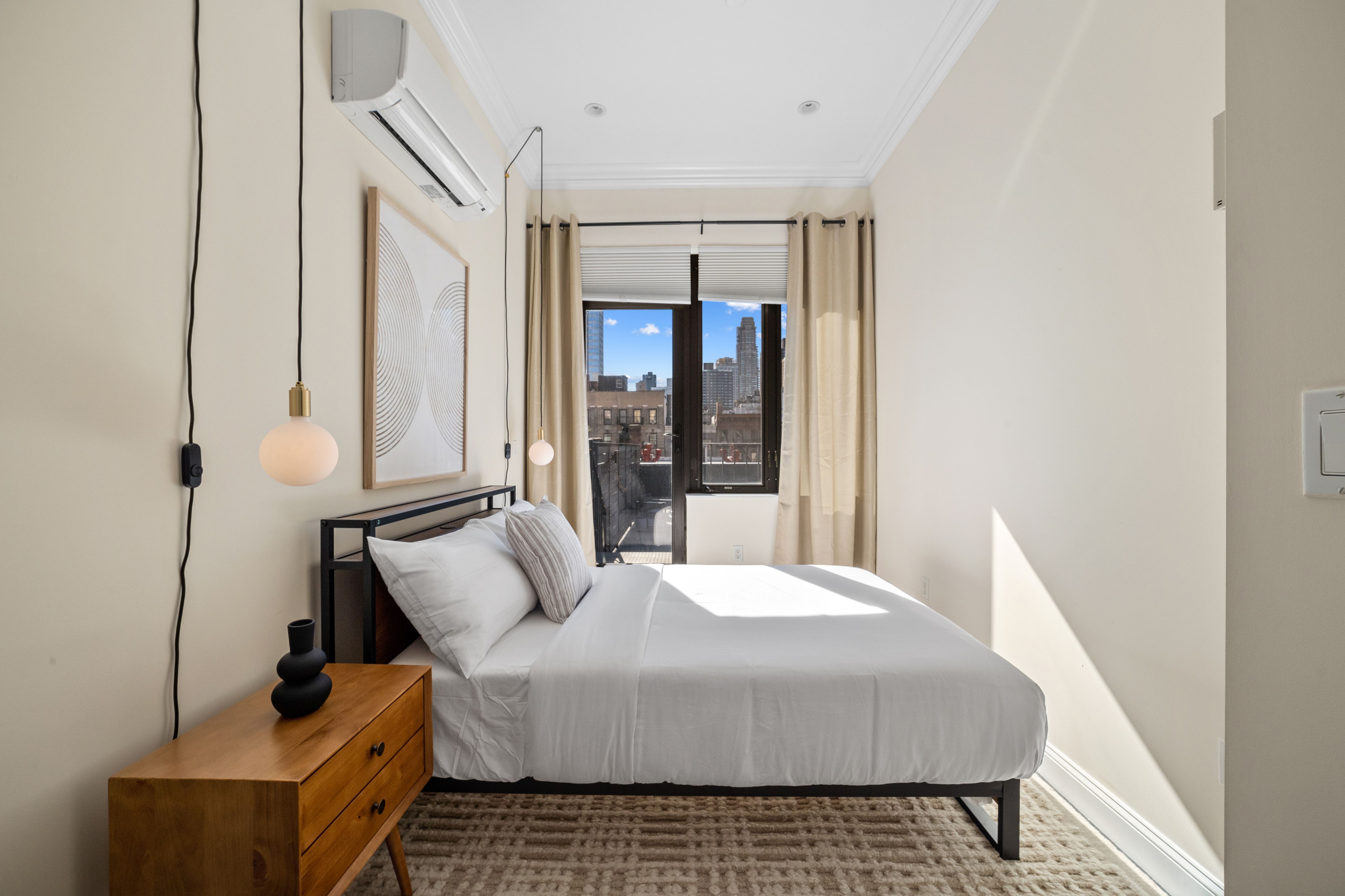 Bedroom with patio access with large bed, hanging night lamps