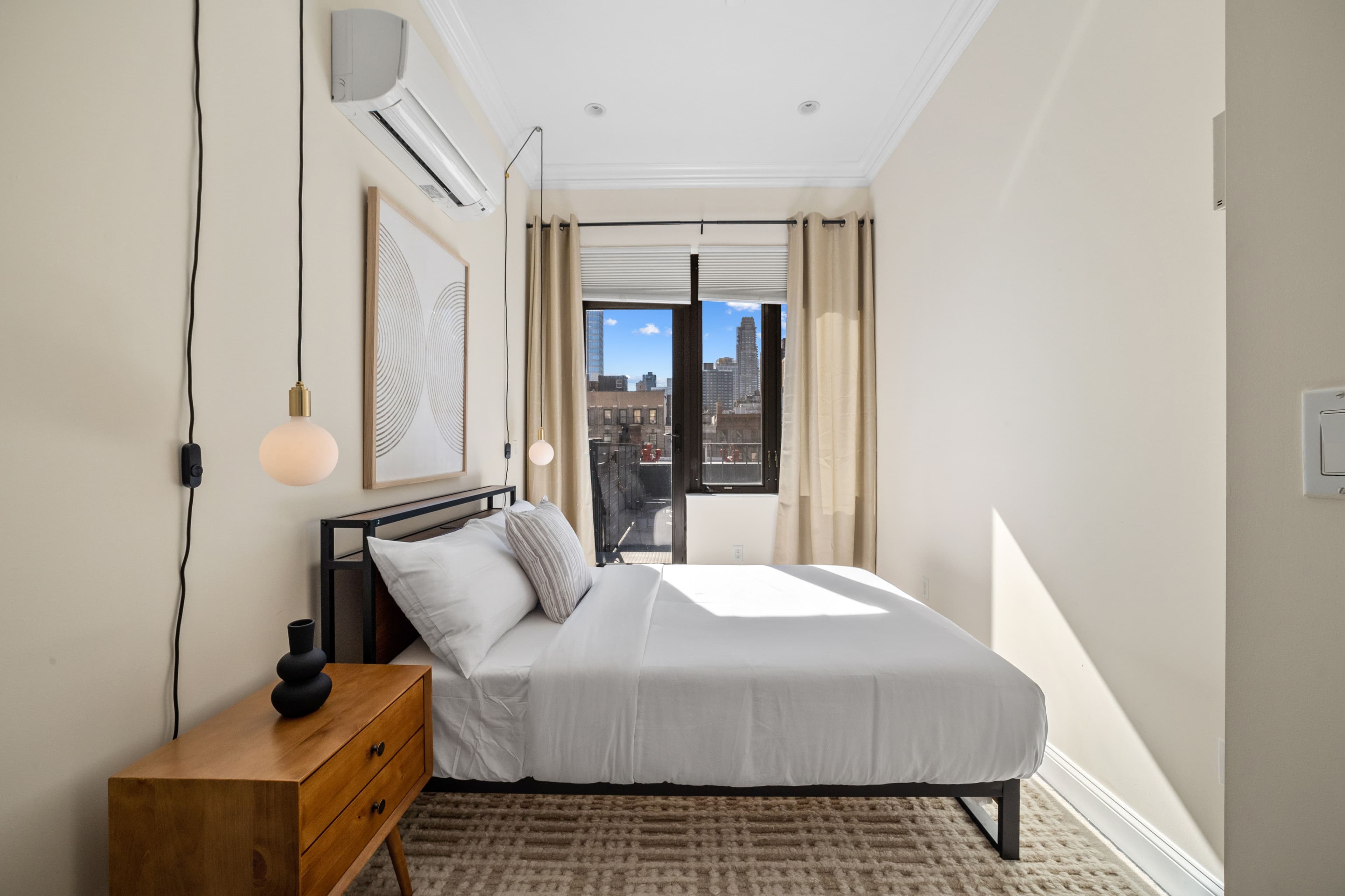 Bedroom with patio access with large bed, hanging night lamps